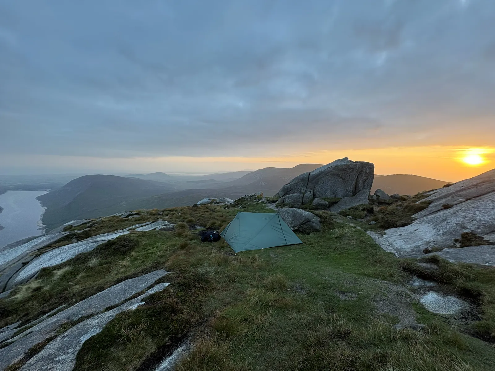 The Durston X-Mid 2 pitched beside a granite tor on the summit of Slieve Doan at sunset, looking out over Lough Shannagh in the Mourne Mountains